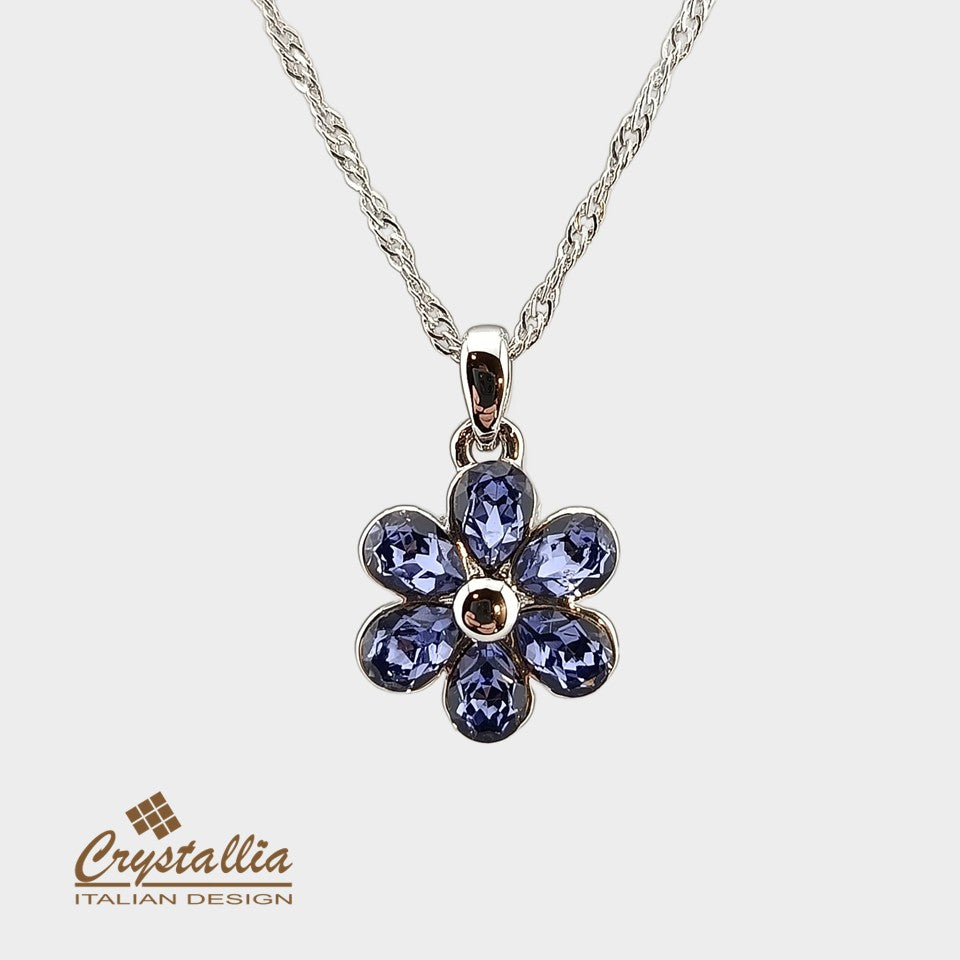 Flower-shaped pendant with purple crystals on a white background, featuring the Crystallia brand.