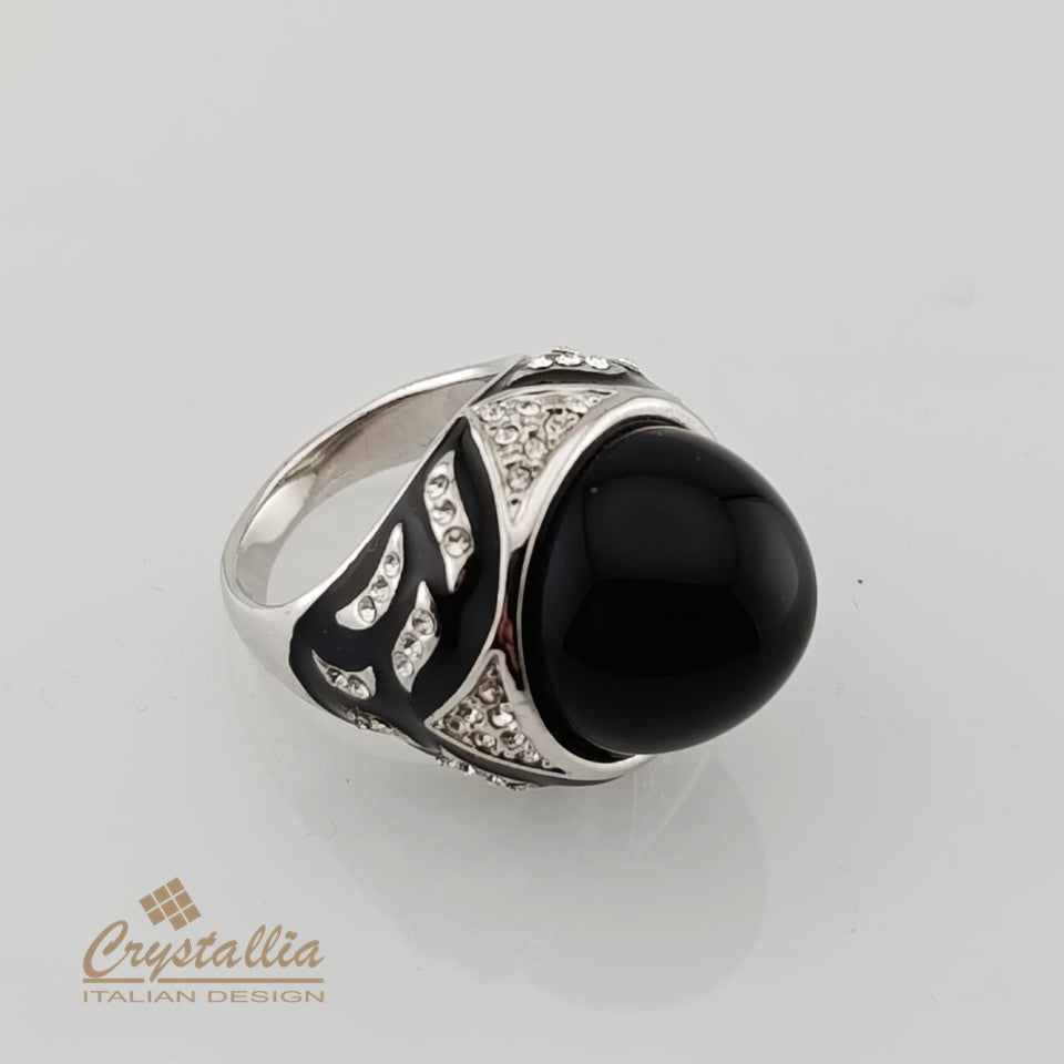 Silver ring with a black gemstone on a gray background, featuring the Crystallia brand.