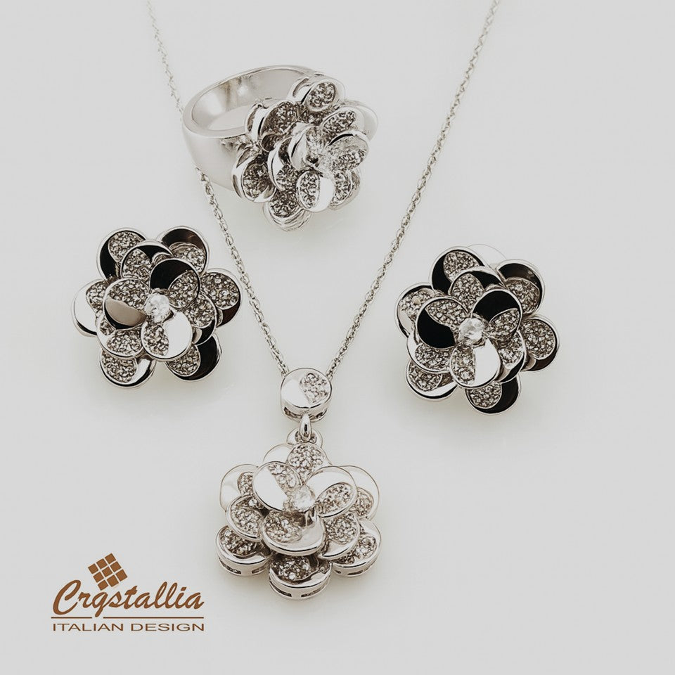 Jewelry set with floral designs including a necklace, ring, and earrings on a white background with 'Crystallia' branding.