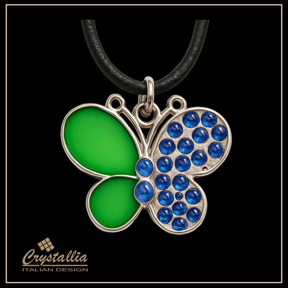 Butterfly-shaped pendant with green wings and blue gemstones on a black background, featuring the Crystallia brand.