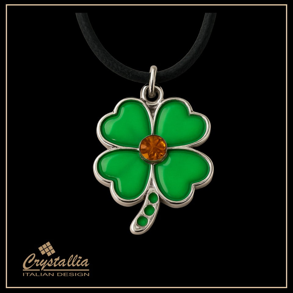 Green four-leaf clover pendant with a brown gemstone on a black background, branded 'Crystallia'.