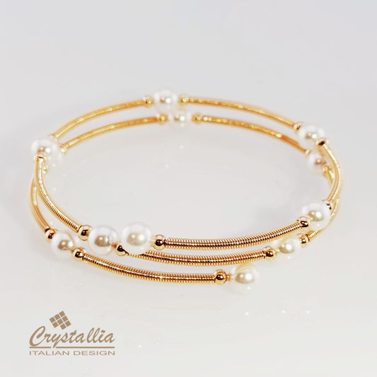 Set of gold and pearl bracelets on a light background with Crystallia branding.