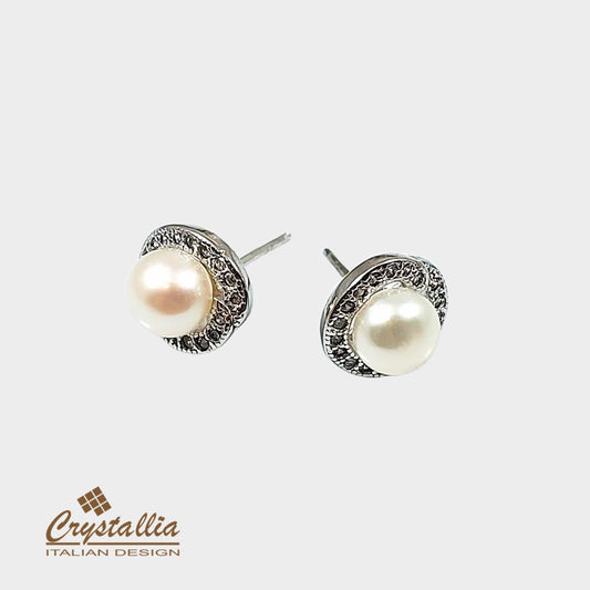 Pearl earrings with silver accents on a white background, featuring the Crystallia brand.