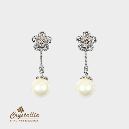 Pair of pearl earrings with decorative tops on a light gray background, featuring the Crystallia brand.