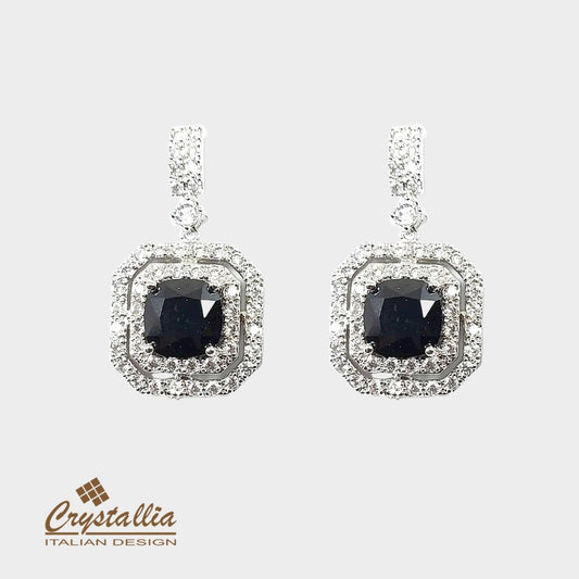 Pair of earrings with black gemstones and diamond-like stones on a white background, featuring the Crystallia brand.