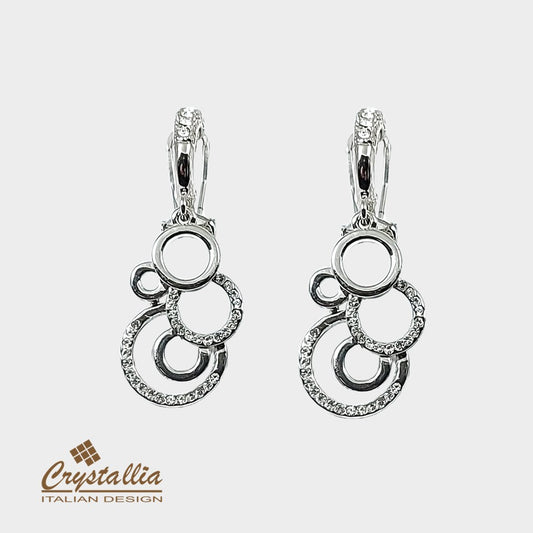 Pair of silver earrings with circular design on a white background, featuring the Crystallia brand.