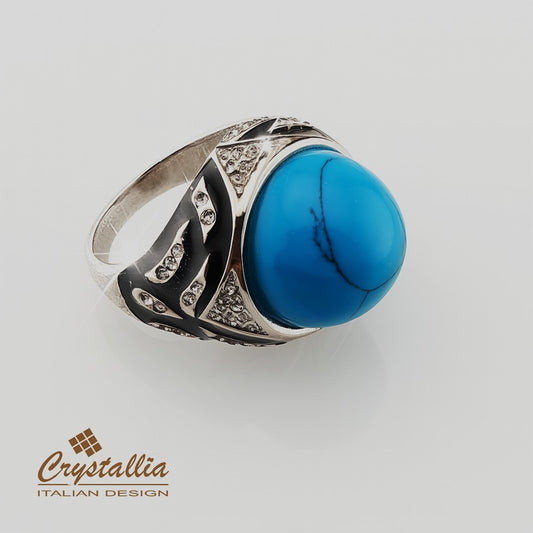 Silver ring with a blue stone on a light gray background, featuring the Crystallia brand.