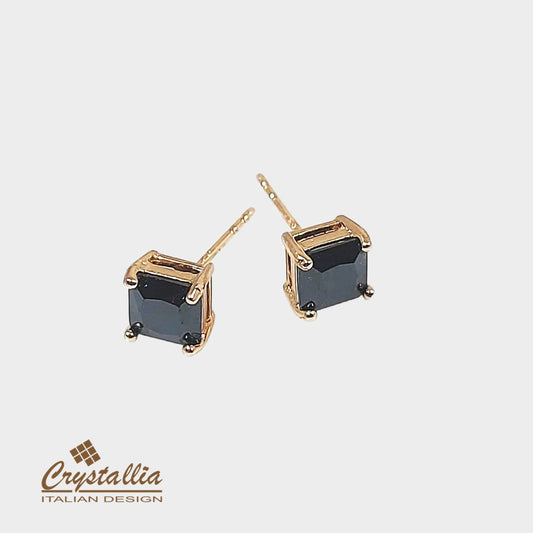 Gold earrings with black gemstones on a white background, featuring the Crystallia brand.