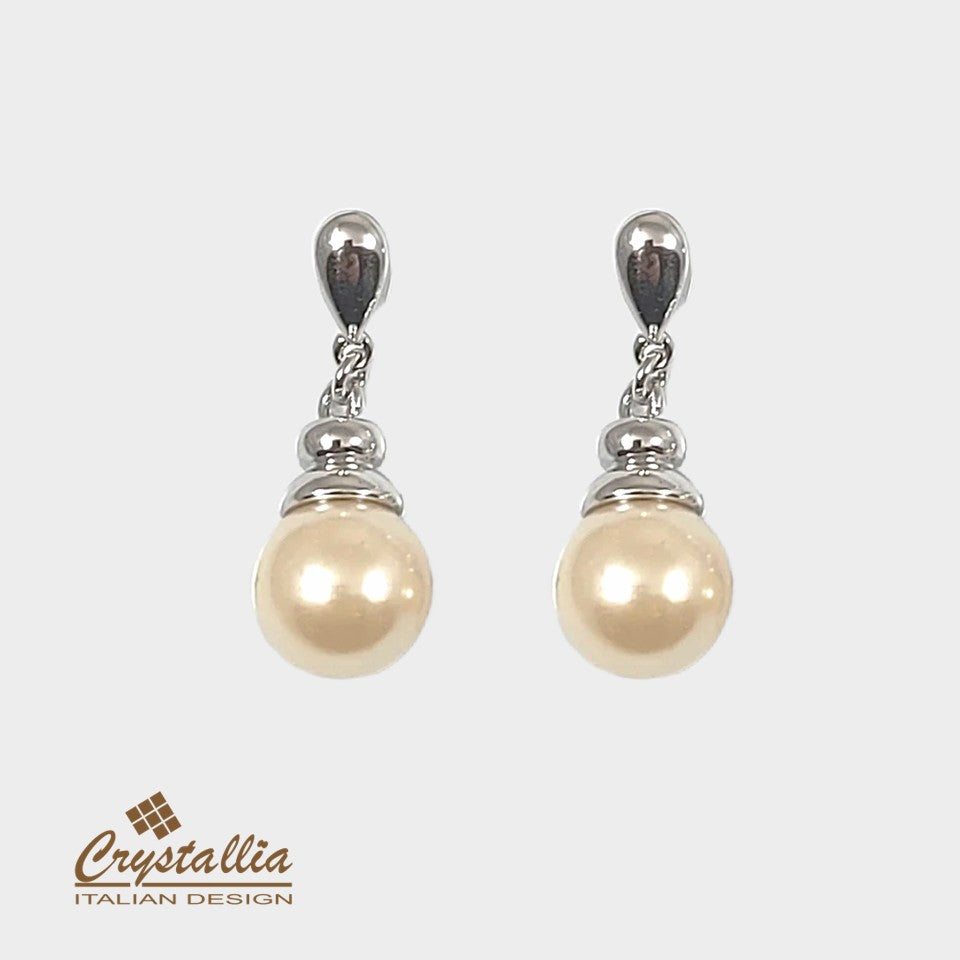 Pearl earrings with silver accents on a white background, featuring the Crystallia brand.