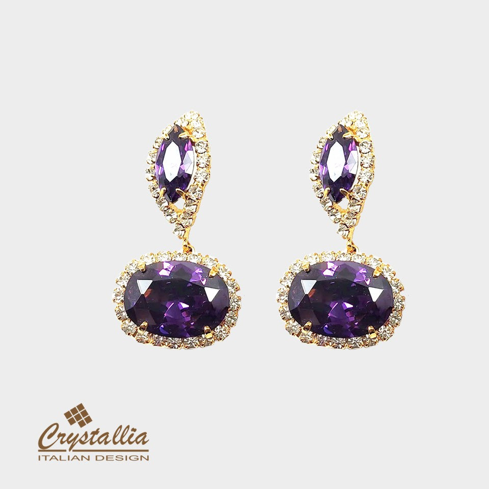Pair of purple gemstone earrings with gold accents on a light gray background, featuring the Crystallia brand.