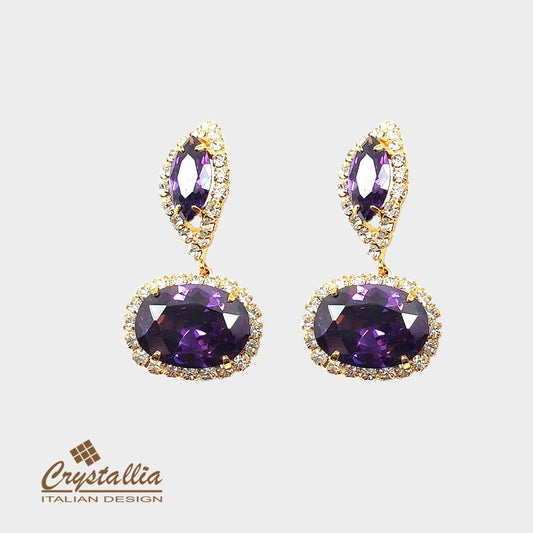 Pair of purple gemstone earrings with gold accents on a light gray background, featuring the Crystallia brand.