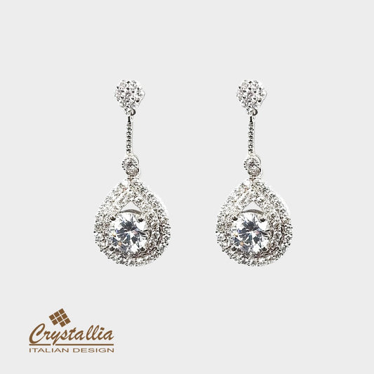 Pair of silver teardrop earrings with clear gemstones on a white background, featuring the Crystallia brand.
