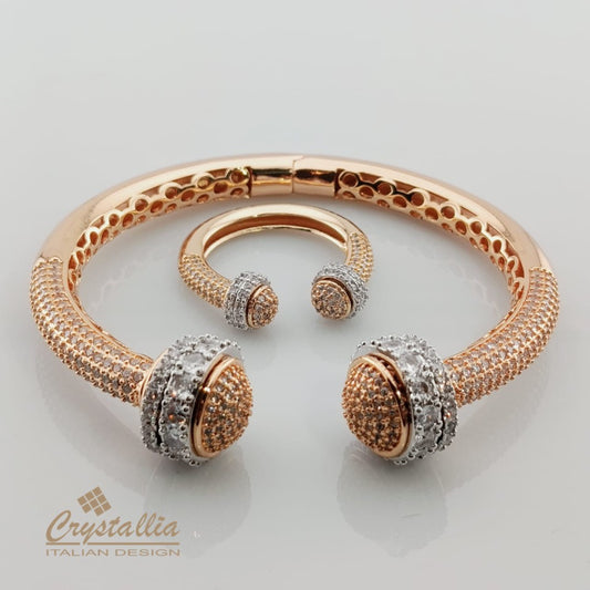 Rose gold bracelet with diamond-like accents on a light gray background, featuring the Crystallia brand.