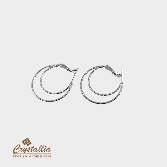 Pair of silver hoop earrings on a light gray background with Crystallia logo.