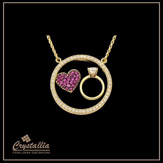 Gold necklace with heart-shaped pendant and ring design on a black background, featuring the Crystallia brand.