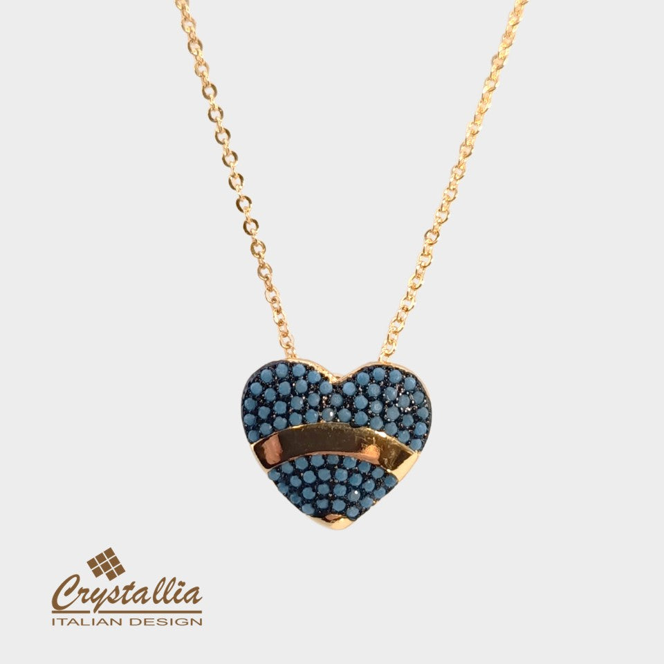 Heart-shaped necklace with blue stones and gold accents on a light gray background, featuring the Crystallia brand.