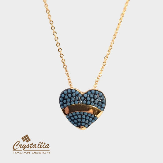 Heart-shaped necklace with blue stones and gold accents on a light gray background, featuring the Crystallia brand.