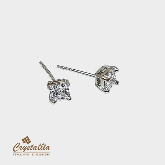 Diamond stud earrings on a light gray background with Crystallia logo.